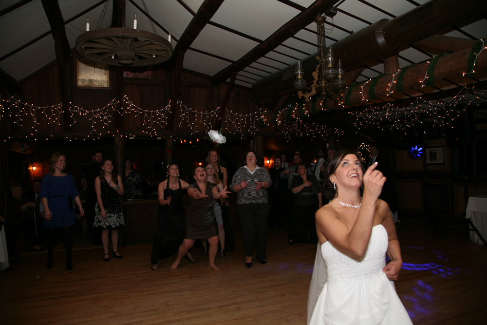Bride Hillary Tarka throws her bouquet at her wedding reception photographed byTessa Spitz Atlantic Coast Entertainment