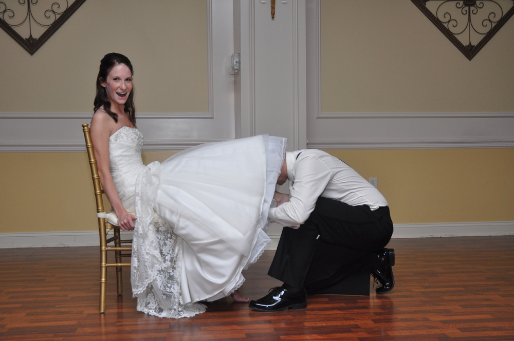 Bride Traci Wright has her garter remove by her husband Devin photographed by Tessa Spitz of Atlantic Coast Entertainment