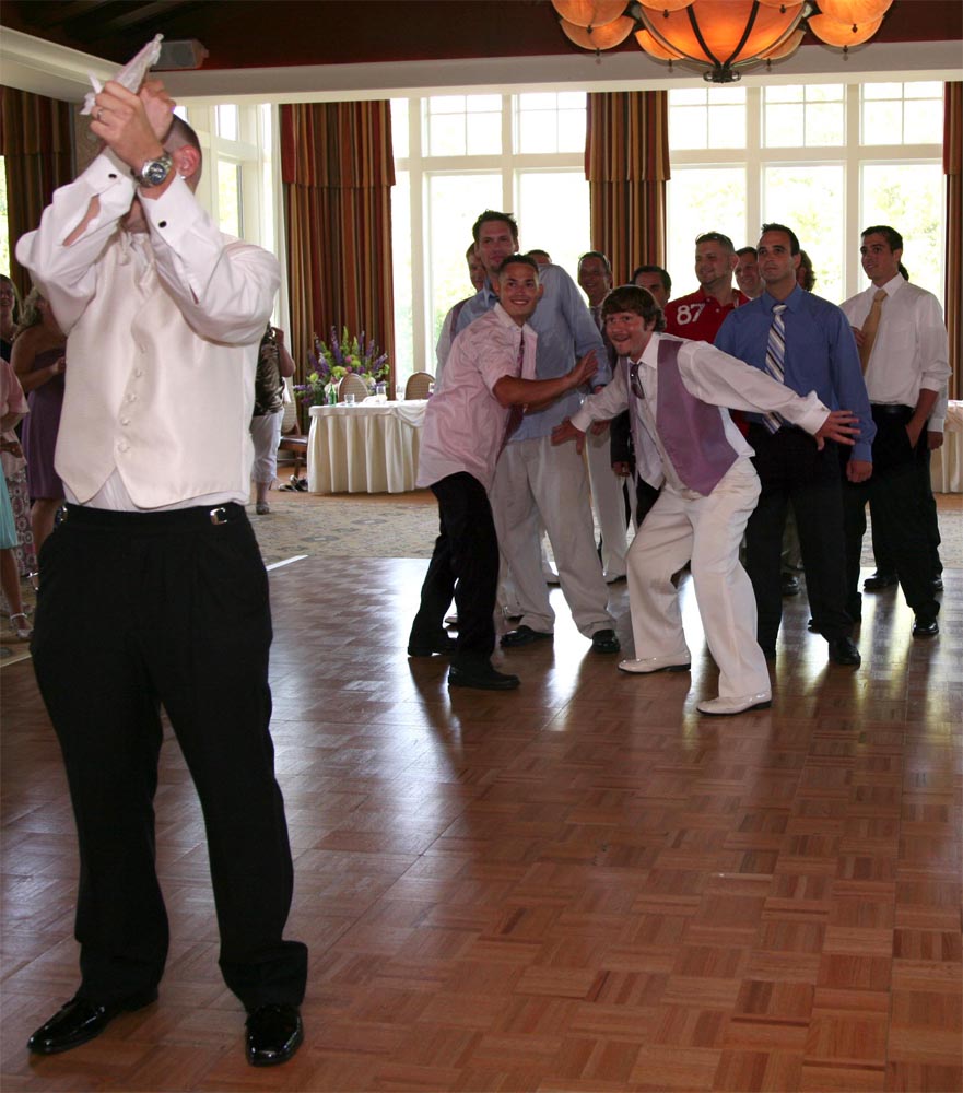 Groom Christopher Godfrey prepares to thow the garter at his wedding reception photographed by Tessa Spitz of Atlantic Coast Entertainment