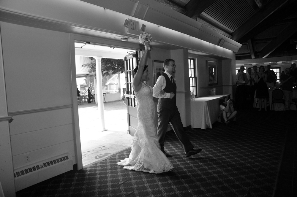 Bride and Groom Heather and Jon Caughey enter their wedding reception football style photographed by Atlantic Coast Entertainment